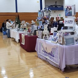 A person browses merchandise at a vendor table in the Quinnipiac recreation center