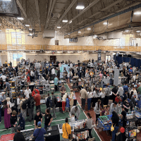 Hundreds of people around tables set up in the Quinnipiac indoor court