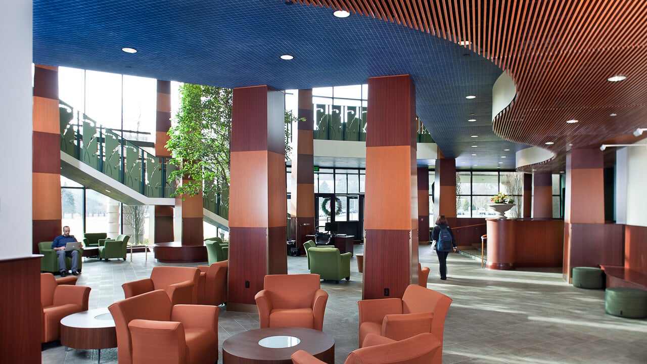 People walk through the North Haven Campus lobby which is brightly lit with windows